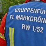 Einsatzkraft; im Hintergrund verunfalltes Fahrzeug