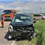 Foto: KS-Images.de/Andreas Rometsch Im Vordergrund verunfalltes Fahrzeug, im Hintergrund Einsatzkräfte und Feuerwehrauto